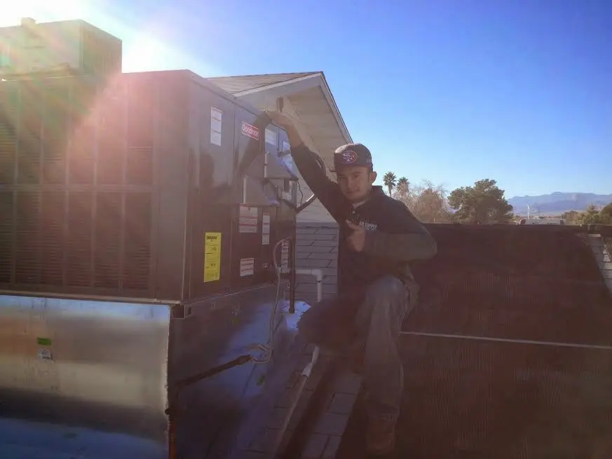 HVAC technician performing Air Duct Repair on a rooftop unit in Lake Hallie